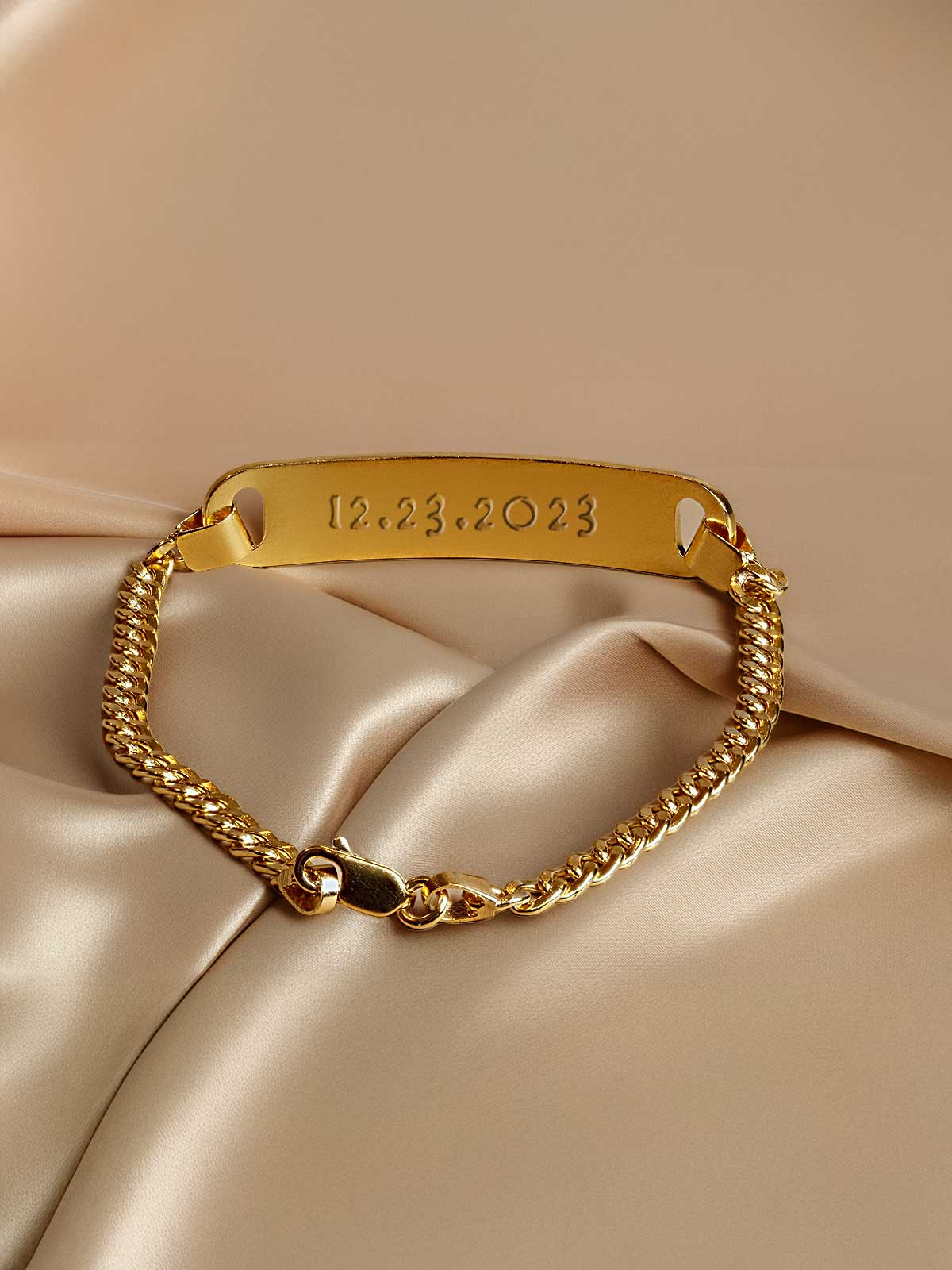 a close up of a gold bracelet on a satin surface