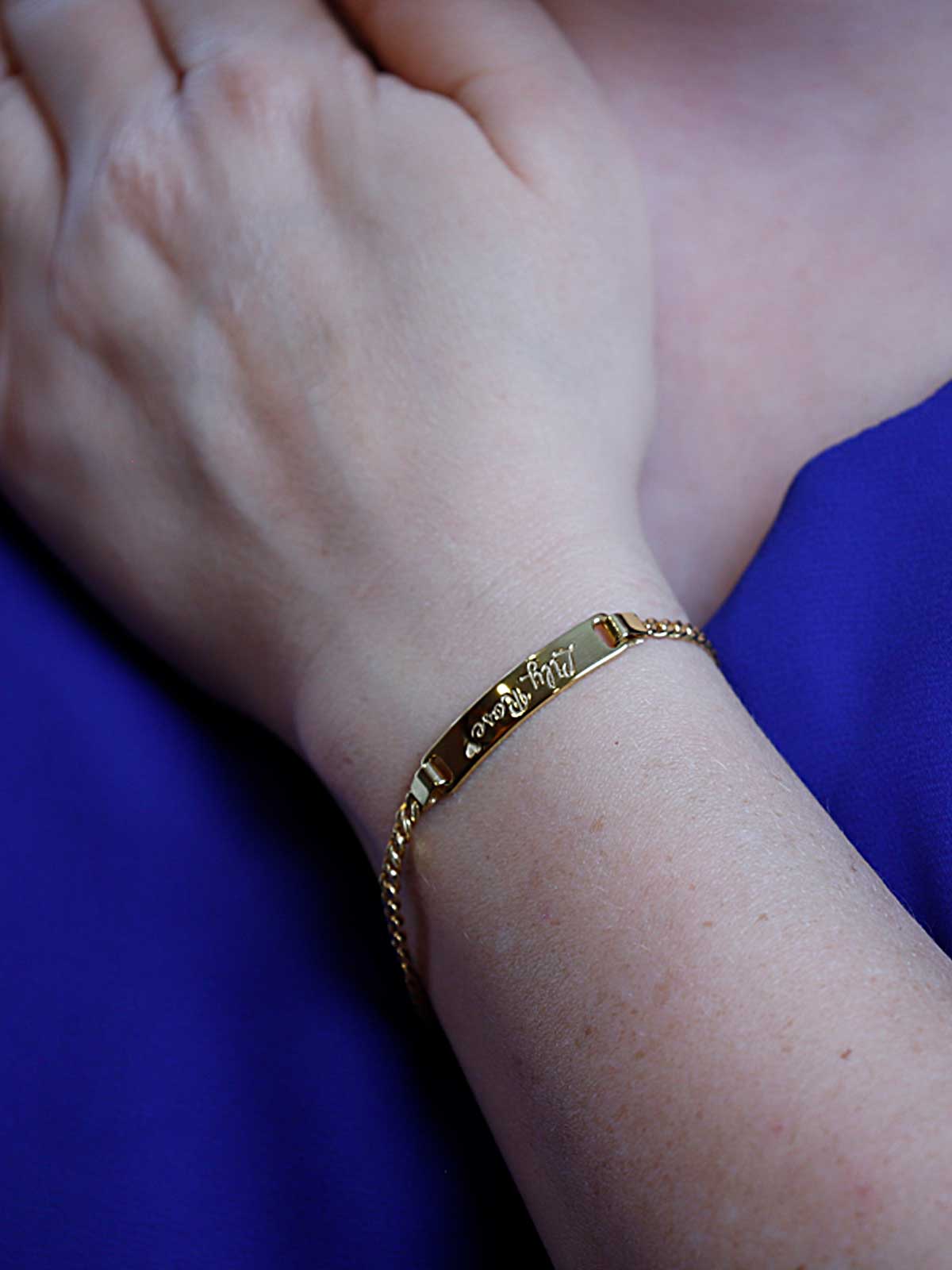 a close up of a person wearing a gold bracelet