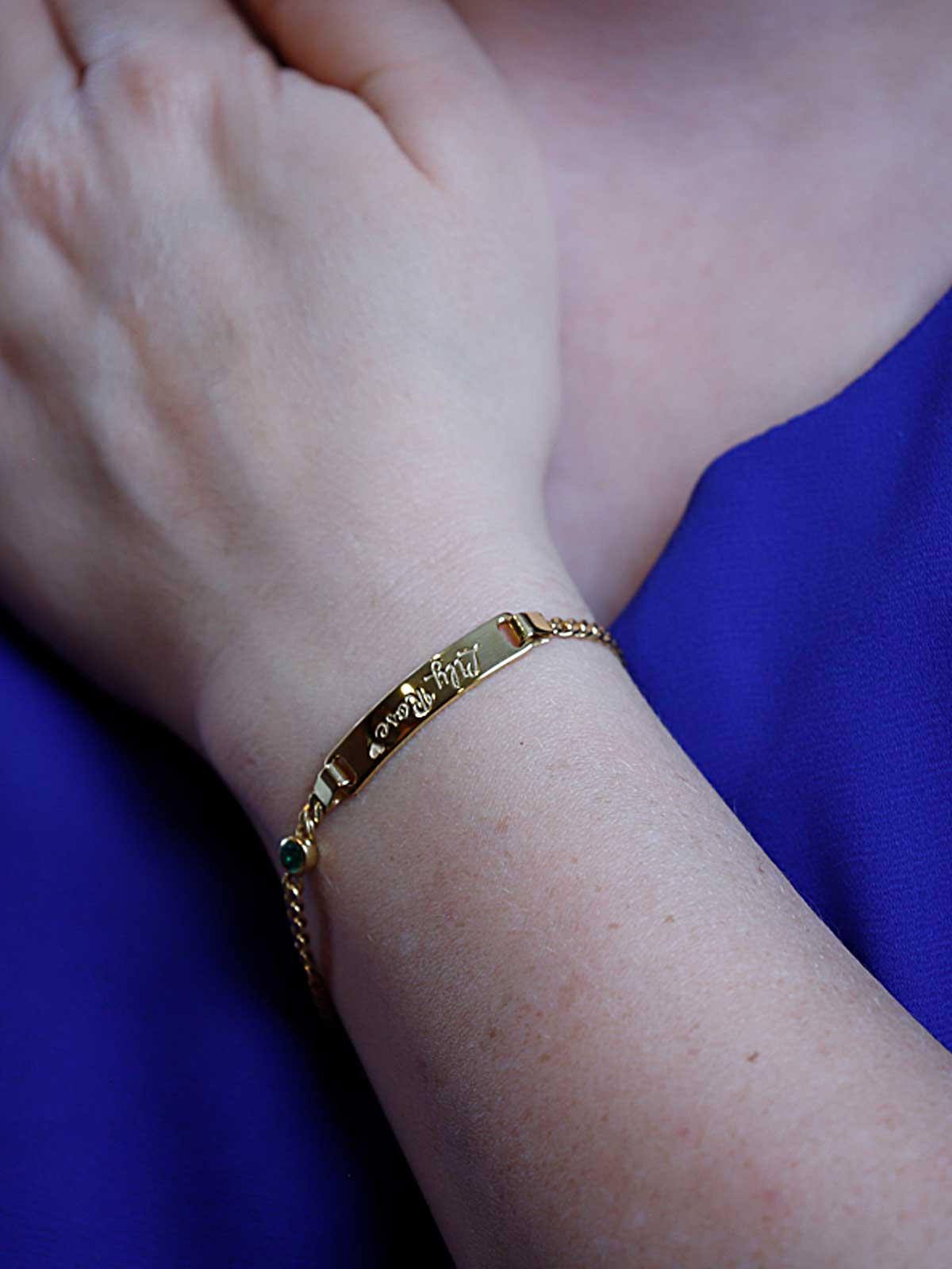 a close up of a person wearing a gold bracelet