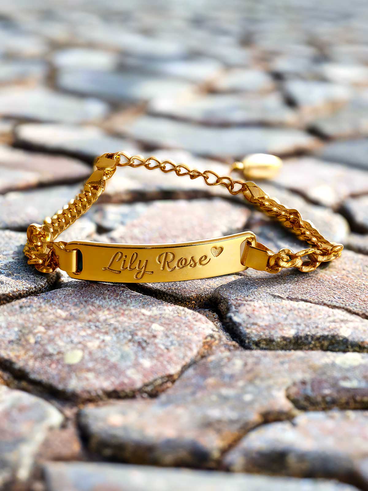 a close up of a gold bracelet on a cobblestone surface