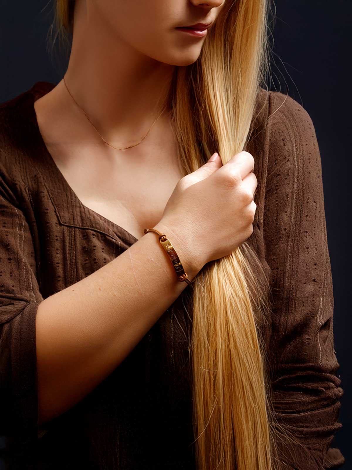 a woman with long blonde hair wearing a bracelet