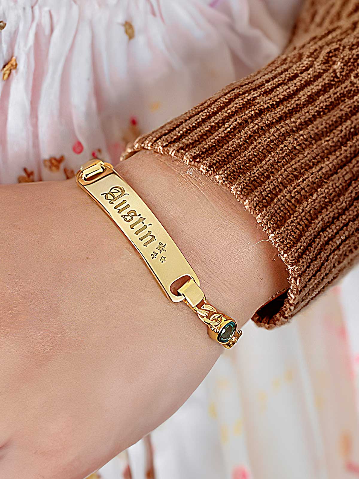 a woman wearing a gold bracelet with a name on it