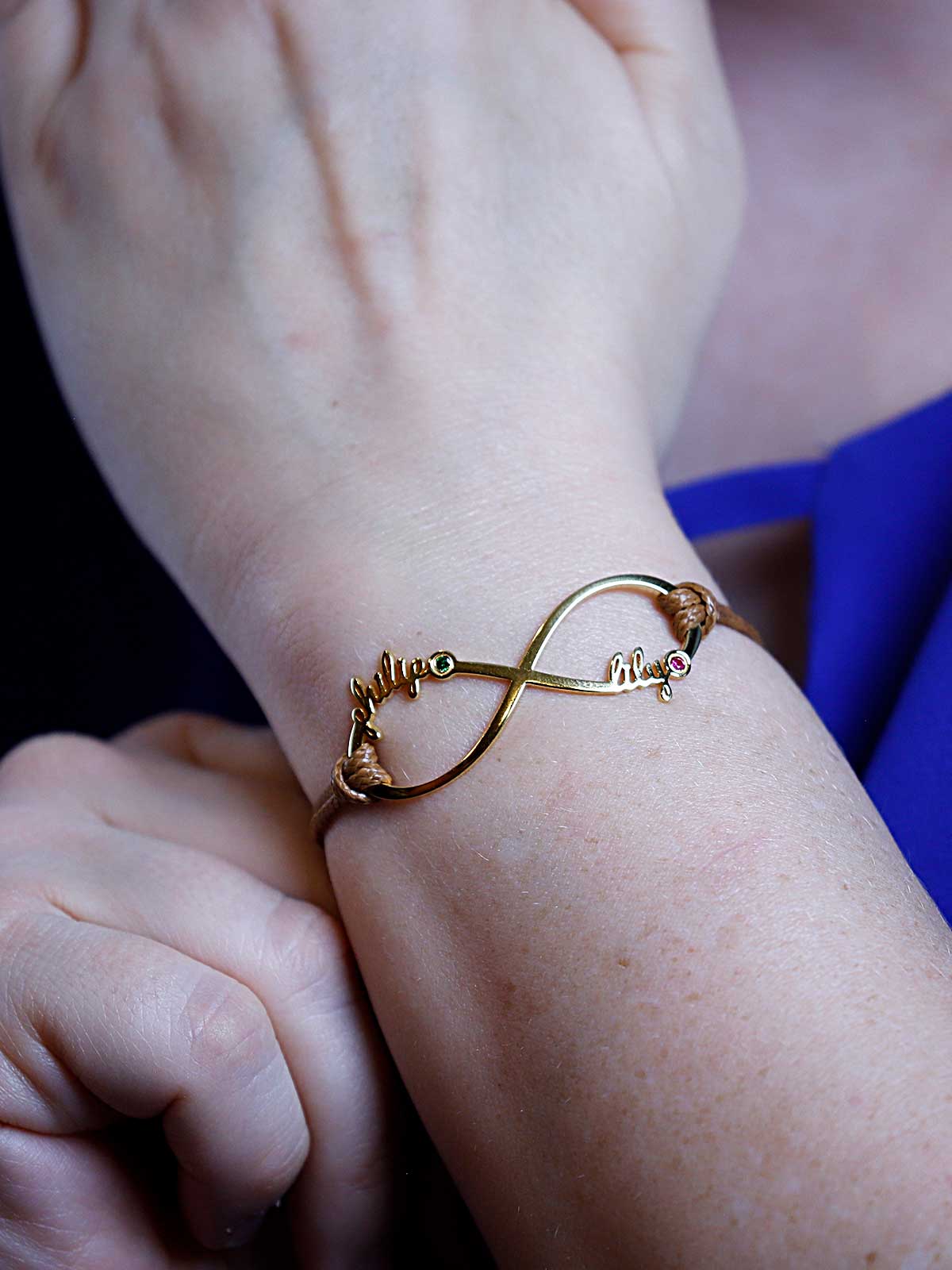 a woman wearing a gold bracelet with a heart on it