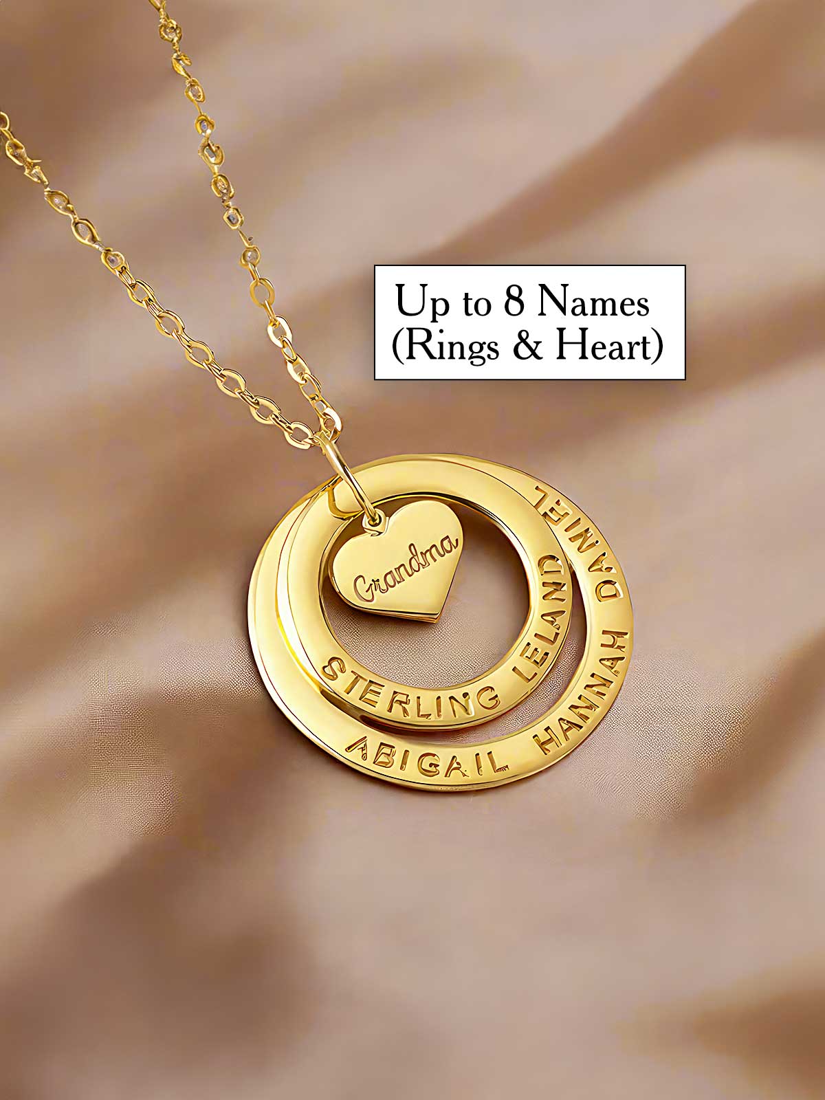 a gold necklace with a heart and two names on it