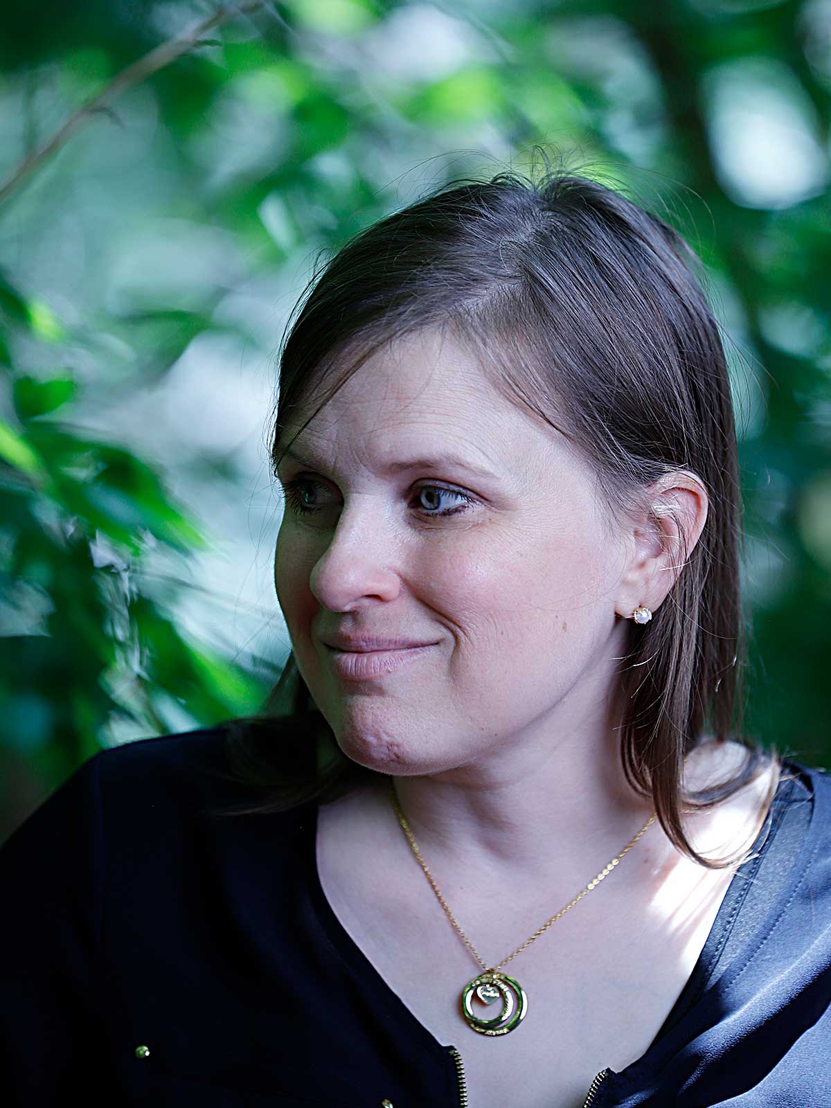 a woman wearing a blue shirt and a necklace