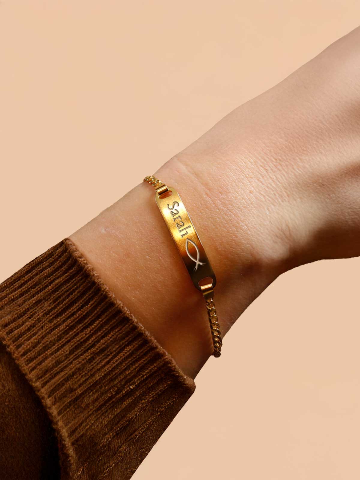 a woman wearing a gold bracelet with a cross on it