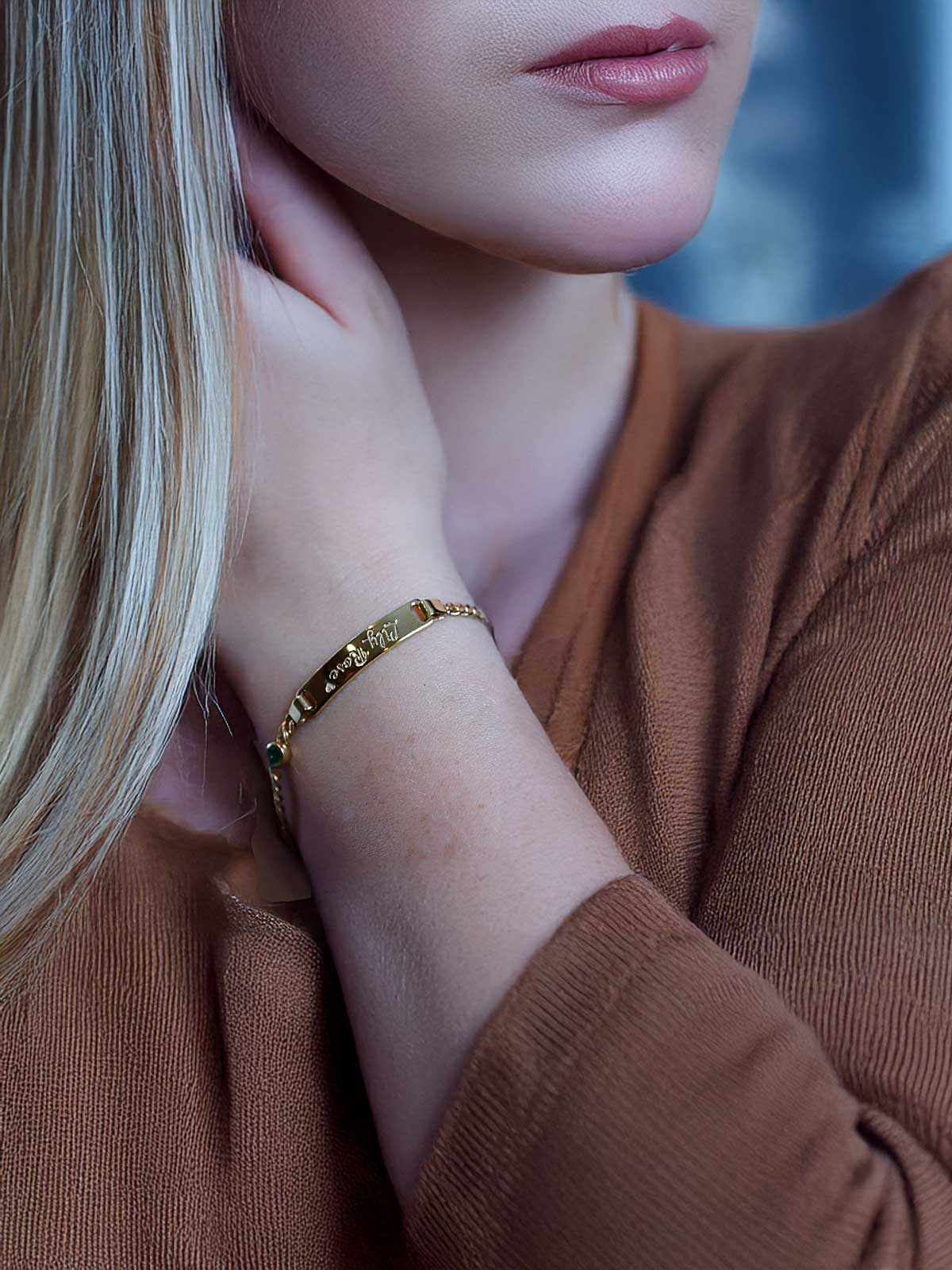 a woman with blonde hair wearing a gold bracelet