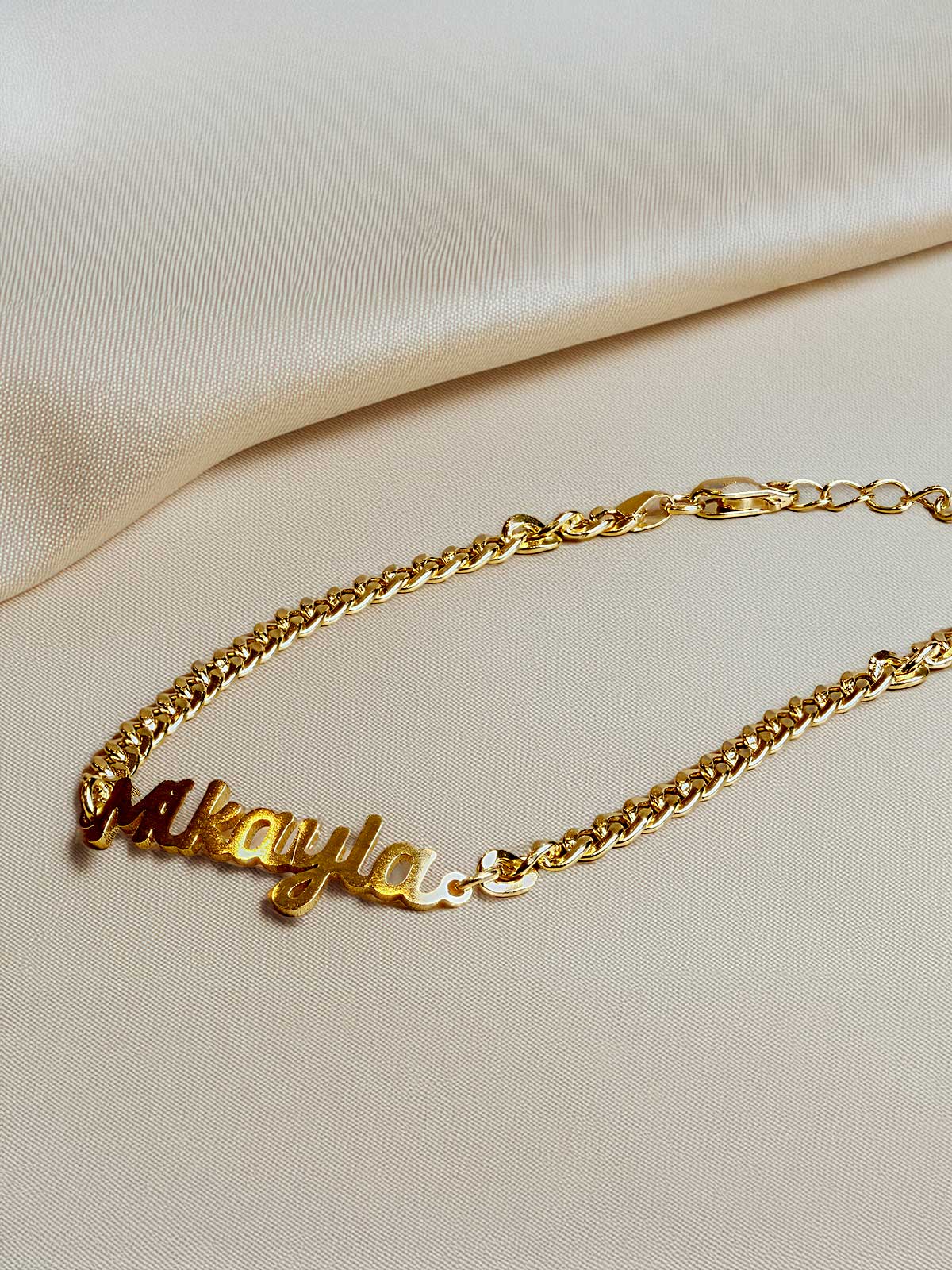 a gold necklace with the word may on it