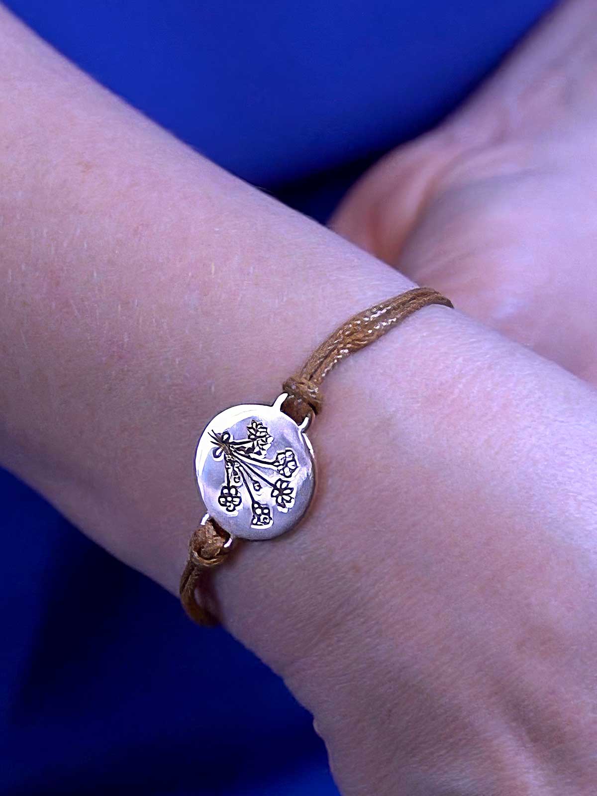 a woman wearing a bracelet with a charm on it