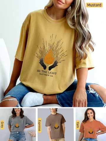 a woman wearing a mustard colored t - shirt with the words be the light on