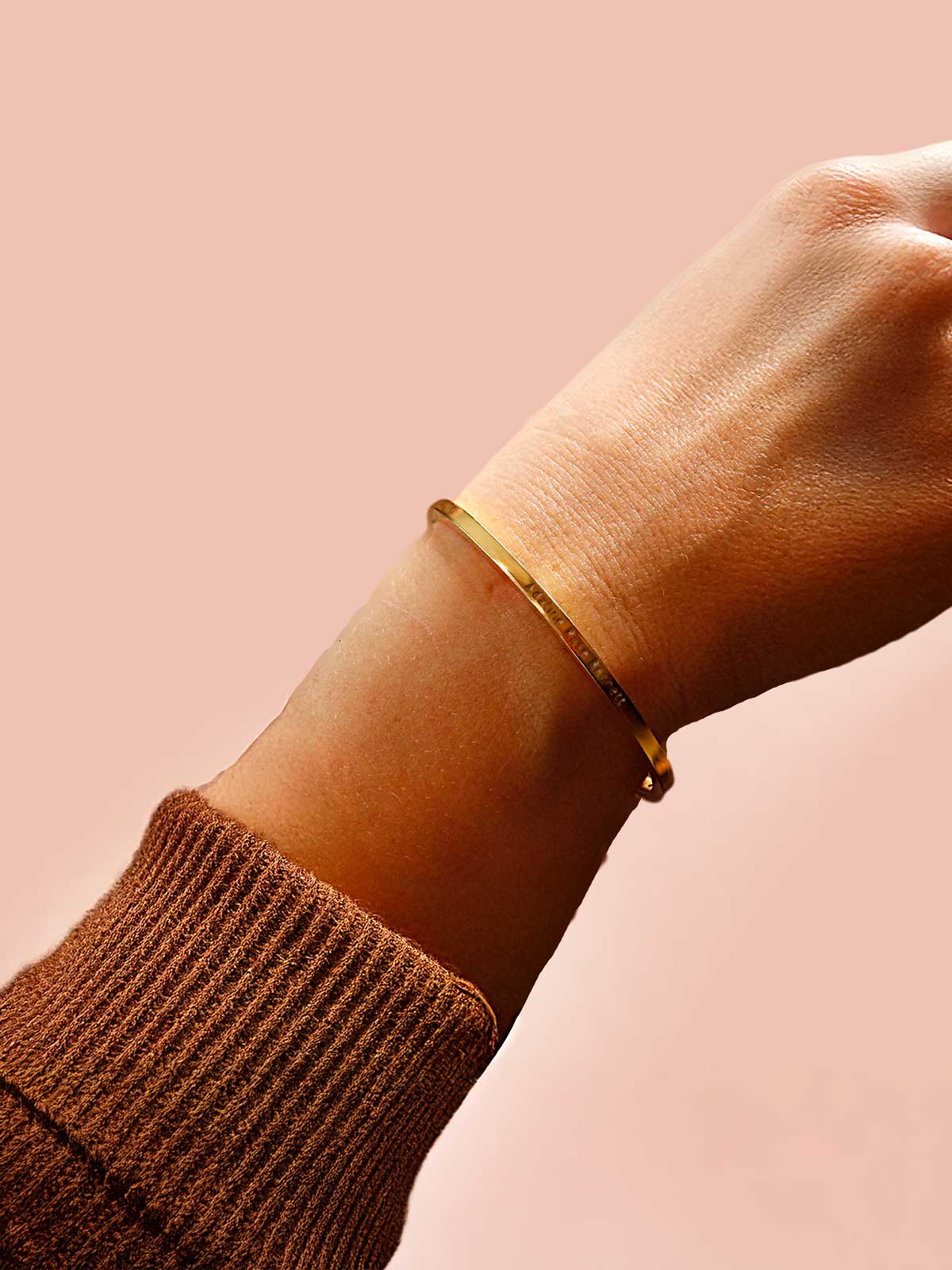 a woman's arm with a gold bracelet on it