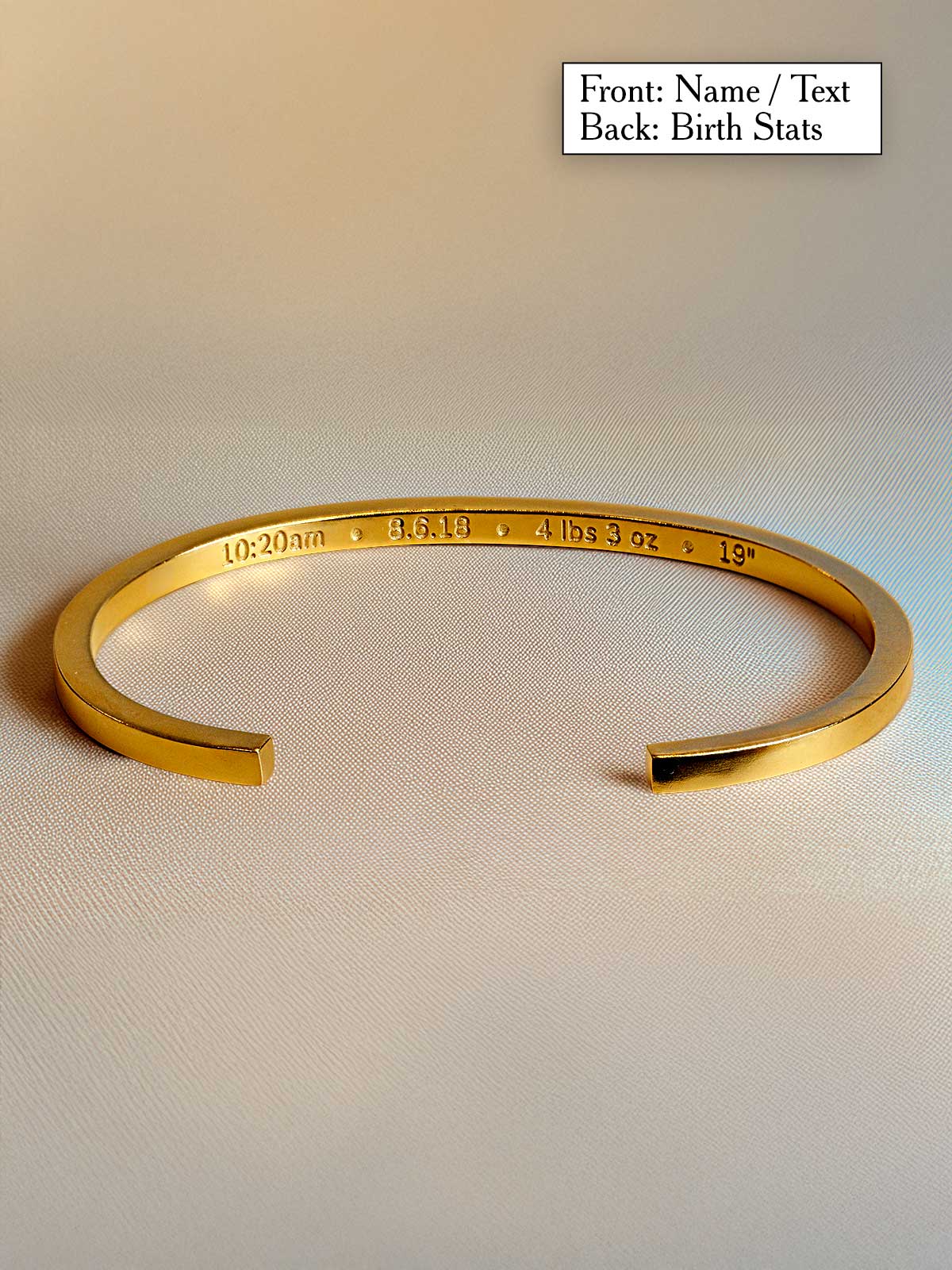 a gold bracelet with a name engraved on it