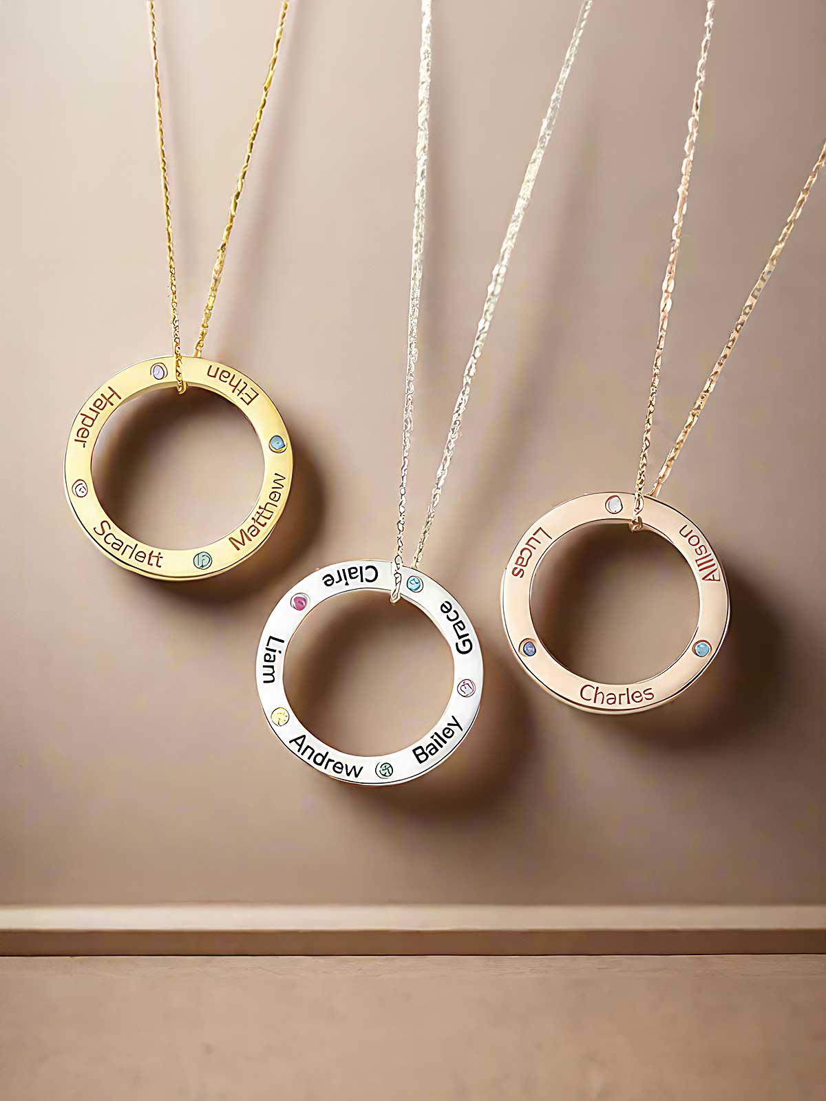 three personalized necklaces hanging on a wall