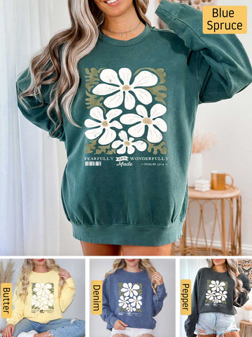 a woman wearing a green sweatshirt with white flowers on it
