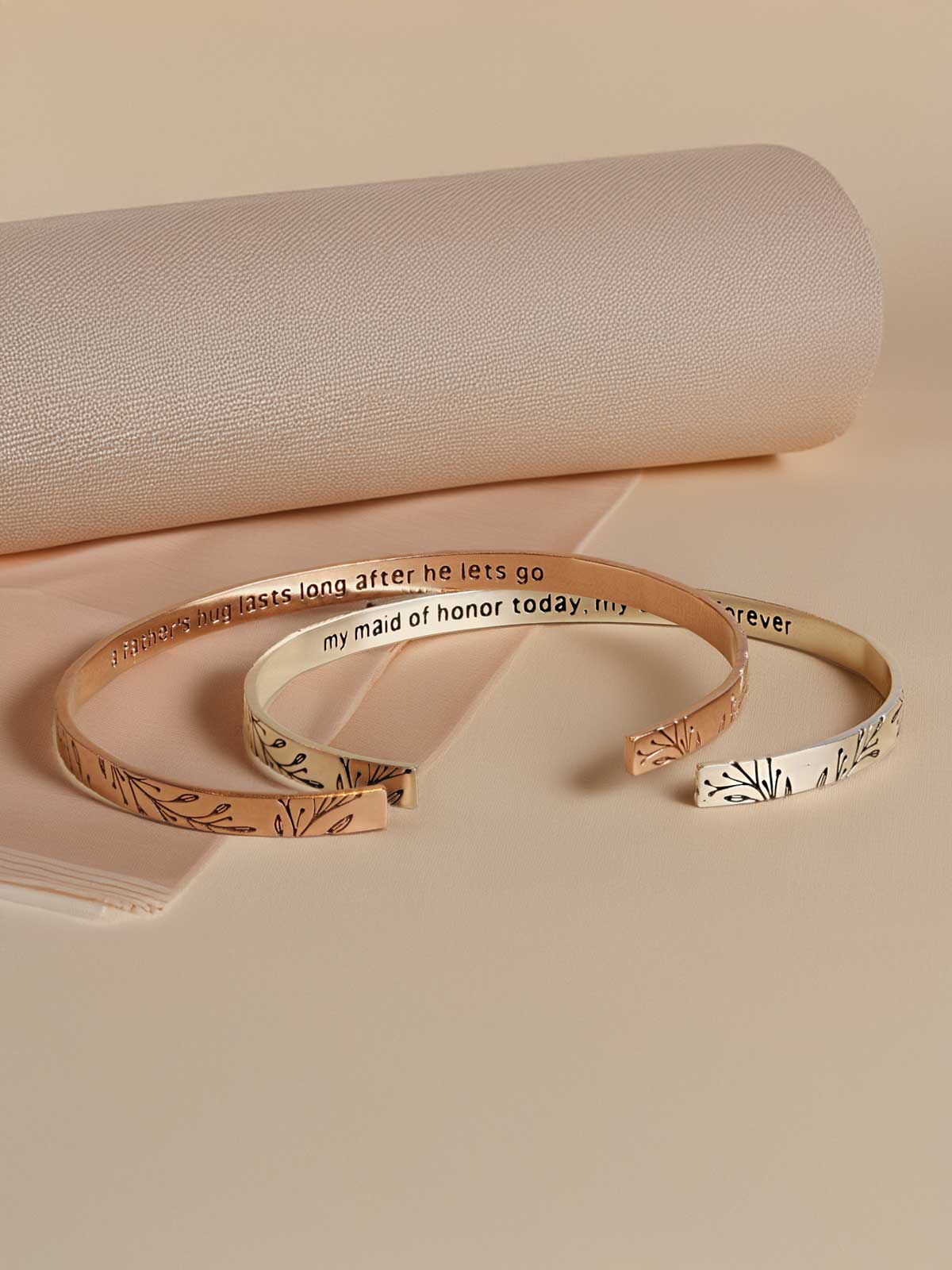 a pair of gold bracelets sitting on top of a table