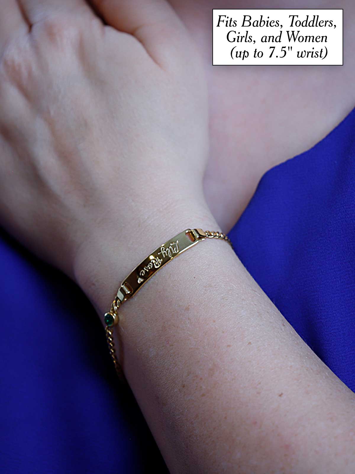 a woman wearing a gold bracelet with a name tag on it